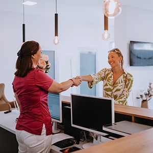 Dental receptionist helping female patient