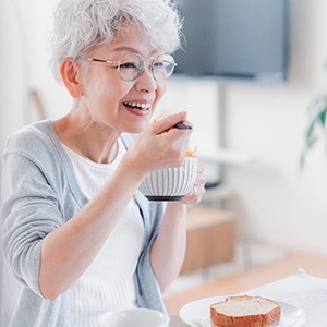 a woman eating while wearing dentures